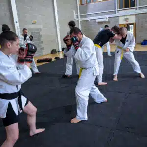 Students drilling punches on focus mitts in a beginners striking session